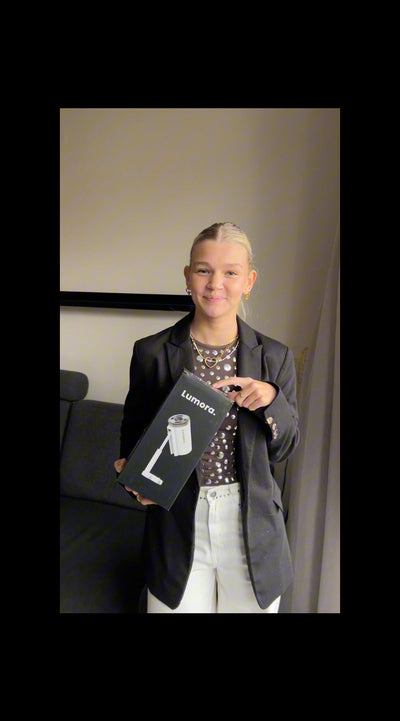 Een klant laat de inhoud van de Lumora beamer doos zien en legt de belangrijkste functies uit, zoals het compacte design en de eenvoudige installatie.